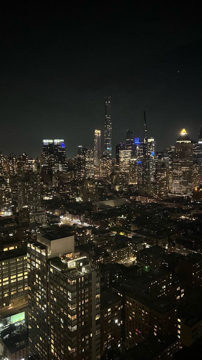 an aerial view of the city at night with skyscrapers lit up in blue and white