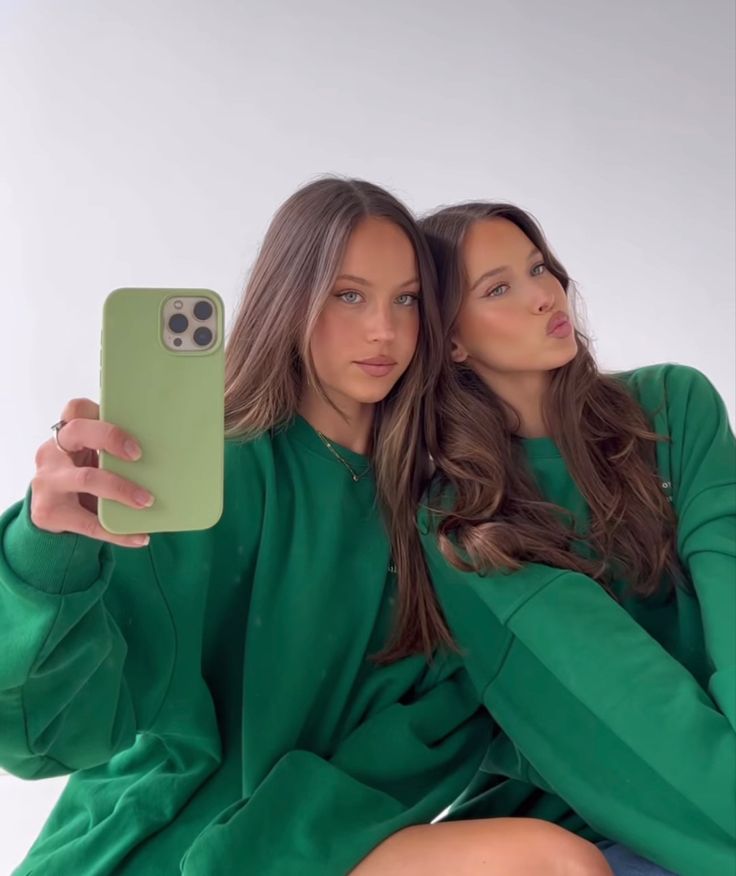 two women sitting next to each other taking a selfie