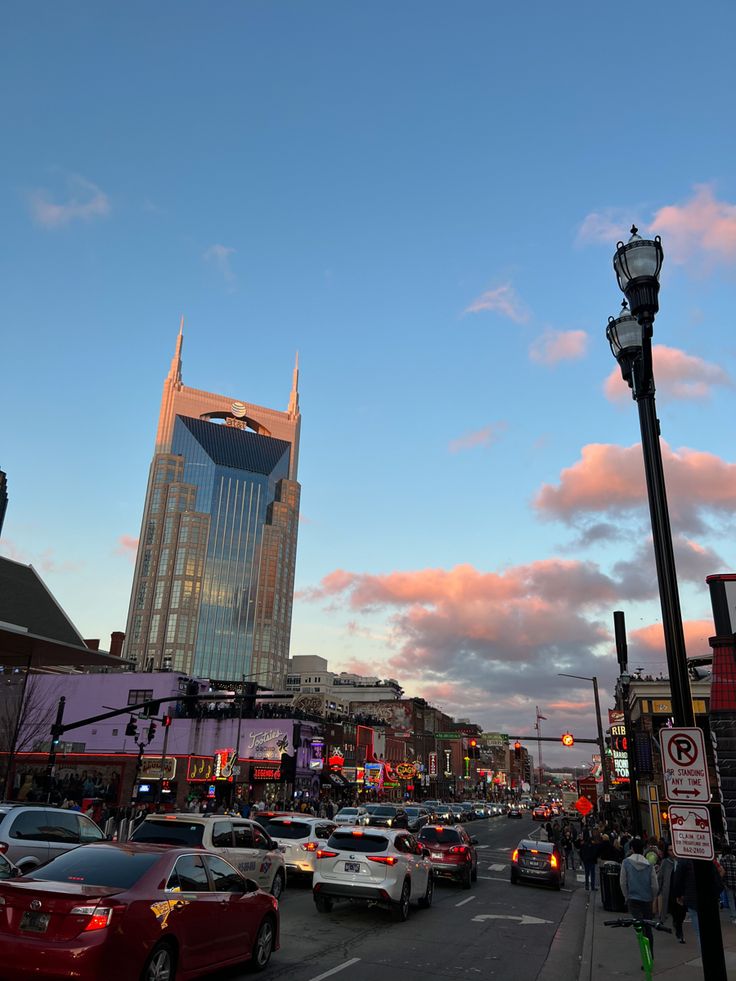 a city street filled with lots of traffic under a cloudy sky at sunset or dawn