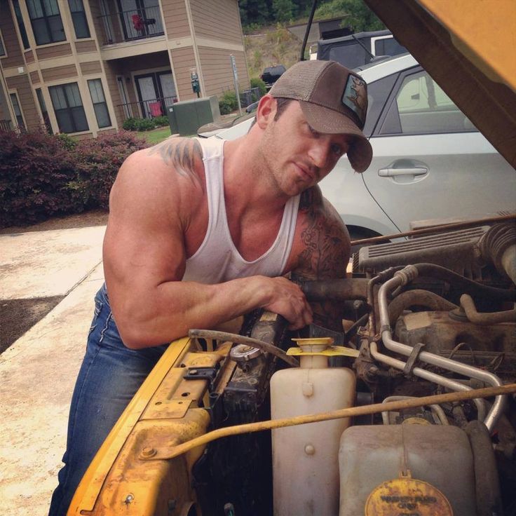 a man working on an engine in his car