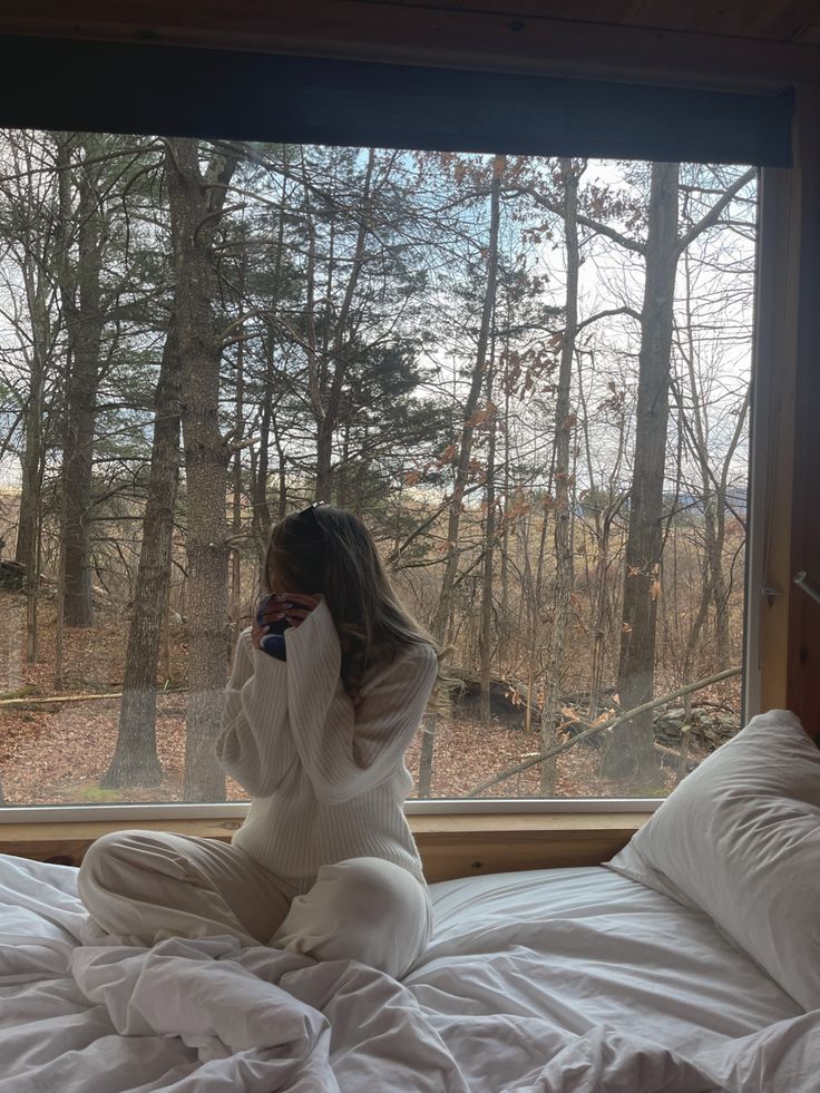 Sitting in front of a window overlooking the woods in winter ny  in a neutral style comfy style cozy winter aesthetic cabin H&M knit sweater and lounge pants very cozy style Cabin In The Woods Aesthetic, Cozy Cabin Aesthetic, Aesthetic Cabin, Cozy Winter Aesthetic, Cabin Outfit, Cabin Weekend, Cabin Vibes, We Are Done, Cute Cabins