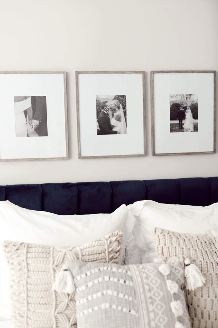 three framed pictures hang on the wall above a bed with white linens and pillows