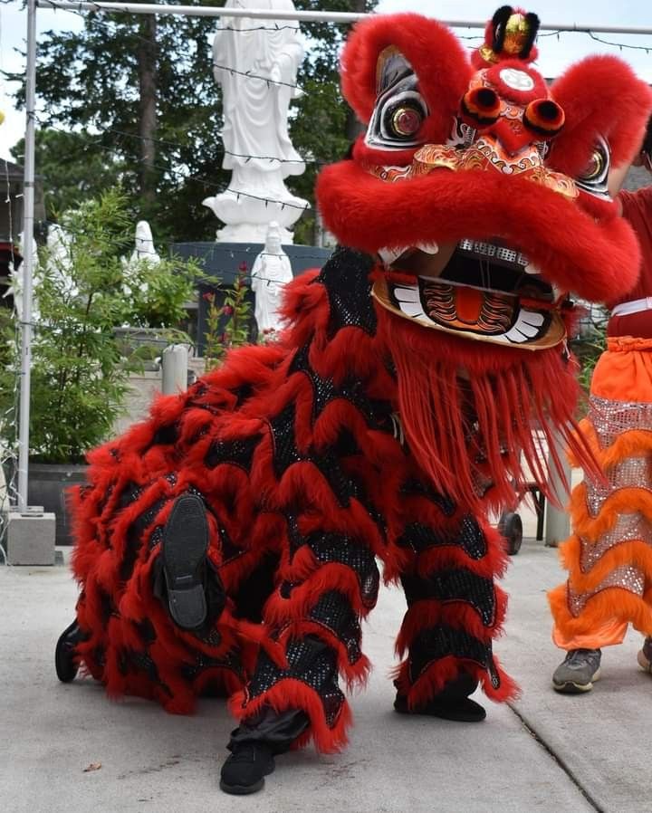 two people dressed in red and black costumes standing next to each other on the sidewalk