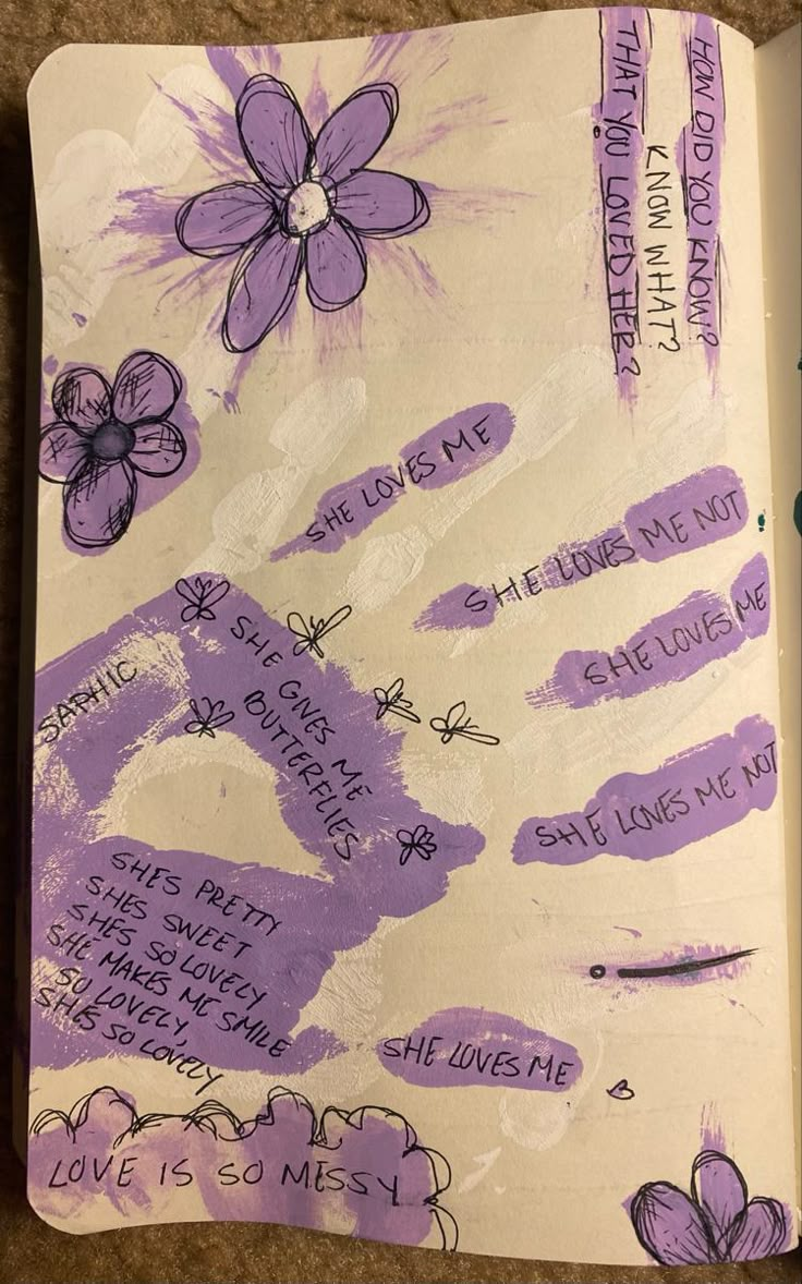 an open notebook with writing on it and purple flowers in the pages that are handwritten