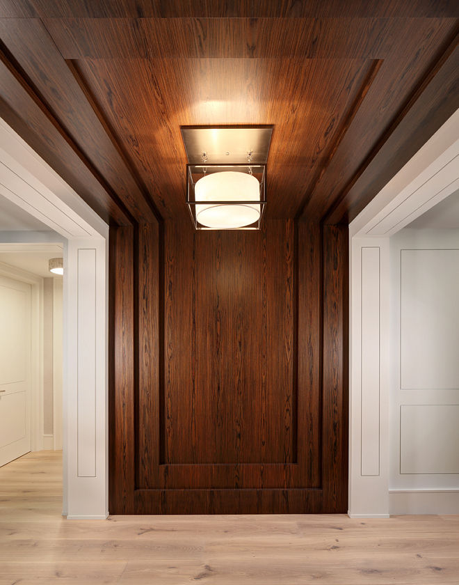 an empty room with wood paneling and lights on the ceiling is pictured in this image