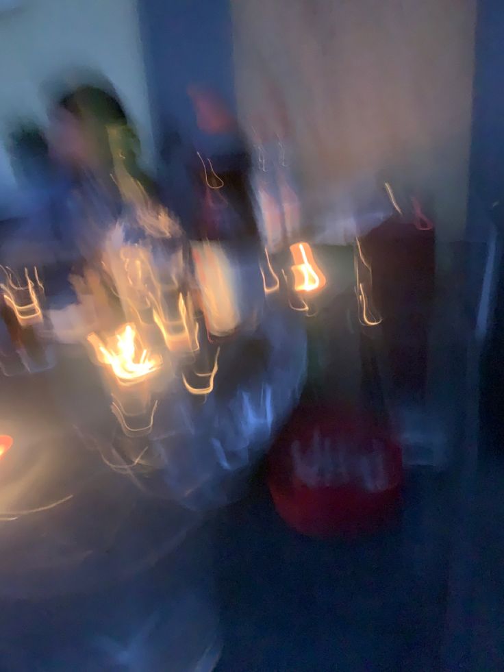 blurry photograph of people sitting at a table with candles in front of the camera