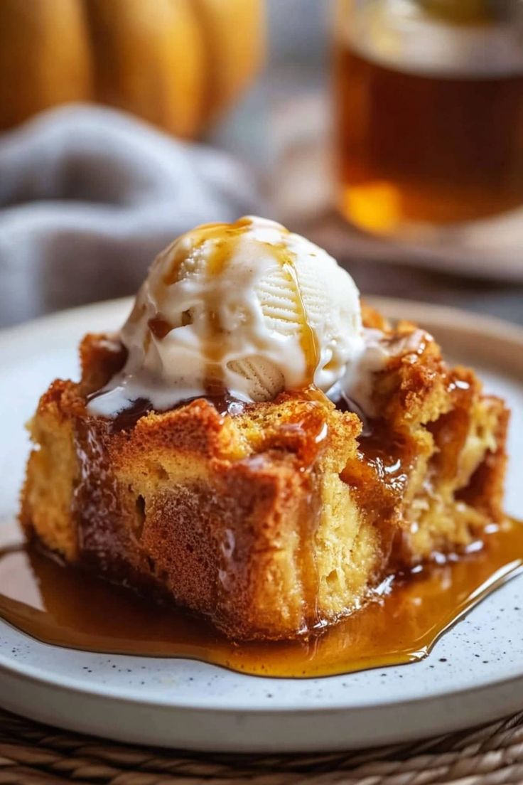 a piece of bread pudding with ice cream on top and caramel sauce drizzled over it