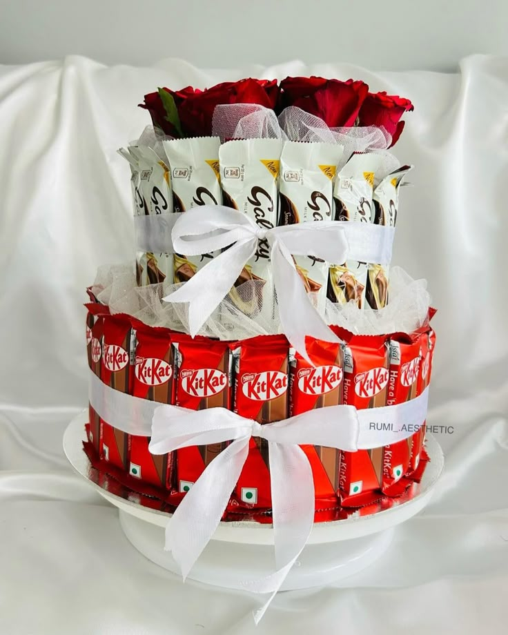 a stack of candy bars wrapped in white ribbon on top of a plate with roses