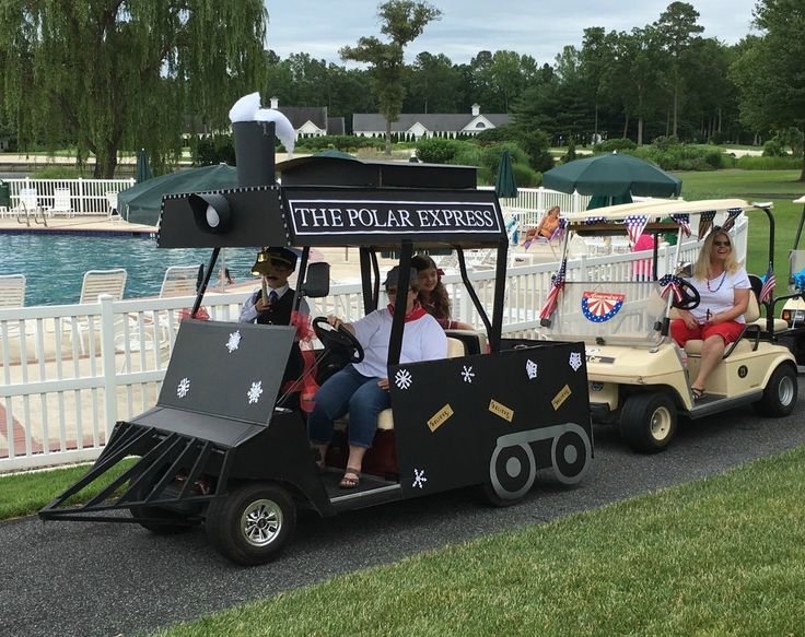 three people riding in a golf cart with flags on it