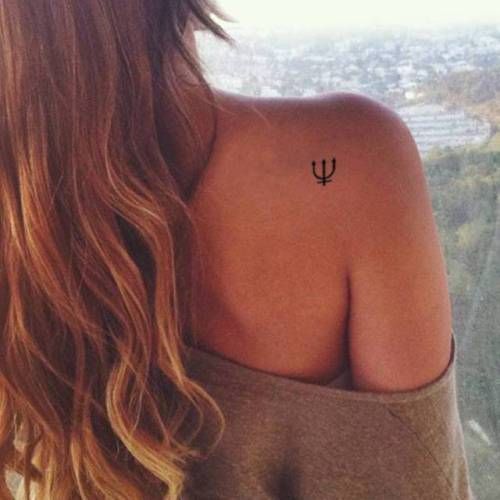 the back of a woman's shoulder with an arrow tattoo on her left arm