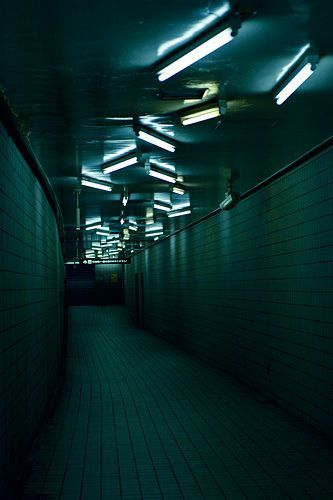 a dark tunnel with lights on the ceiling