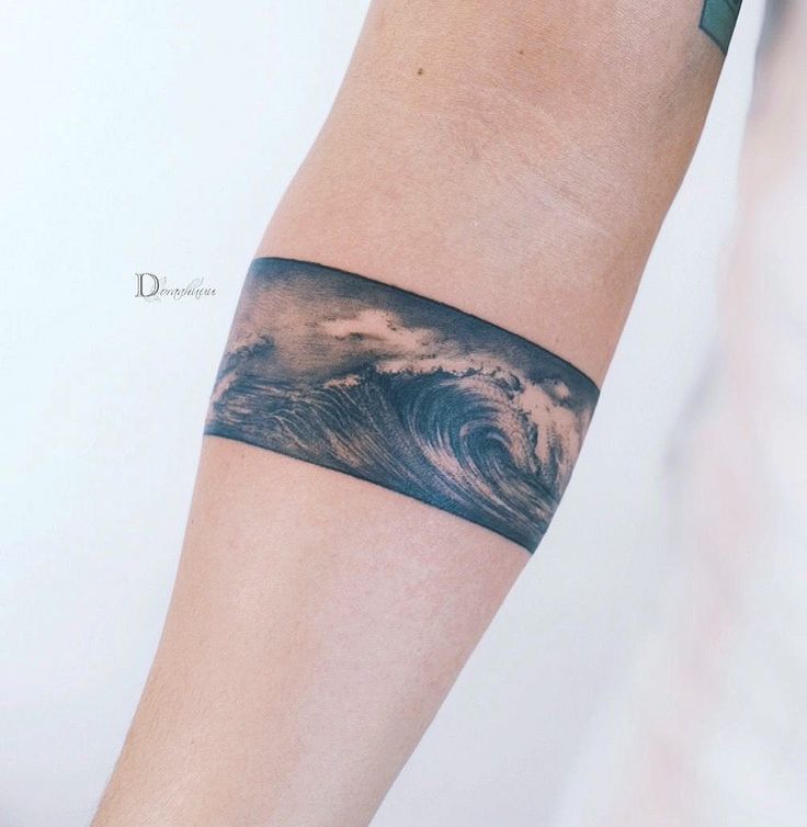 a man's arm with a wave tattoo on it