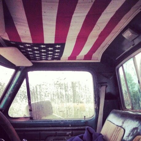 the interior of a vehicle with an american flag painted on the roof and window panels