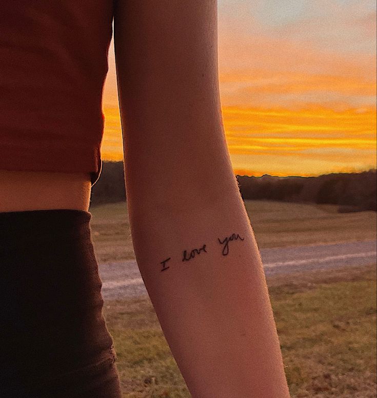 a woman's arm with the words i love you written in cursive font