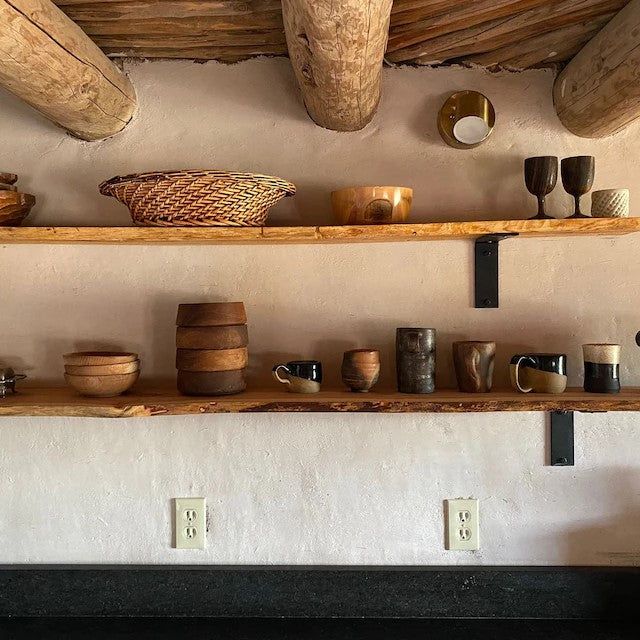 some shelves filled with cups and bowls on top of each other in front of a fire place