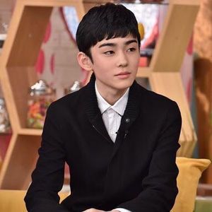 a young man in a suit sitting down