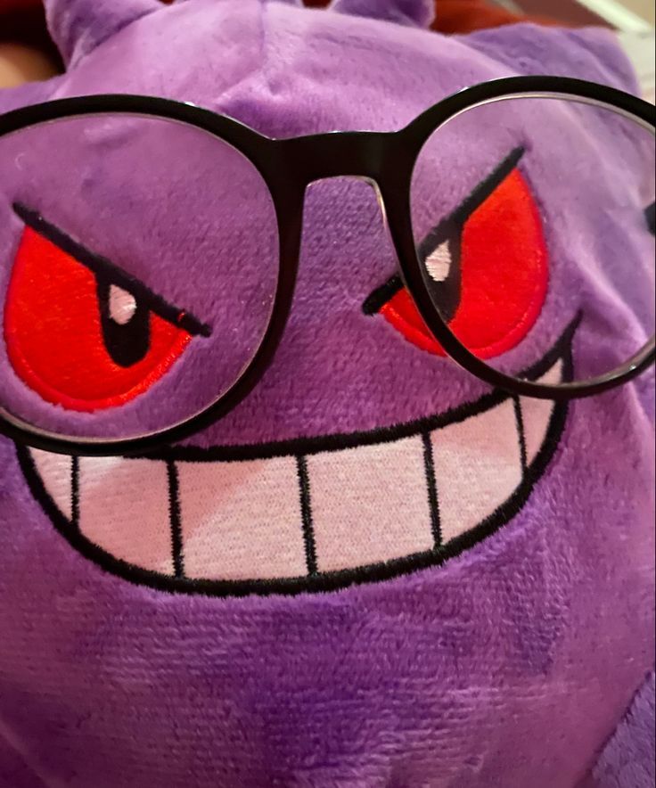 a purple stuffed animal with glasses on it's face