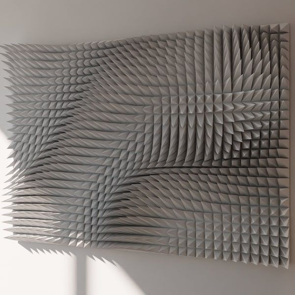 an abstract sculpture is shown against a white wall