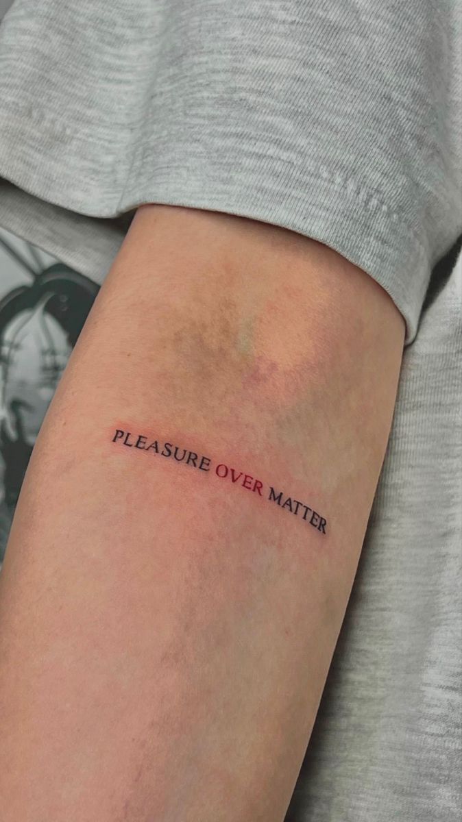 a person with a tattoo on their arm that says, pleasure over matter in red ink