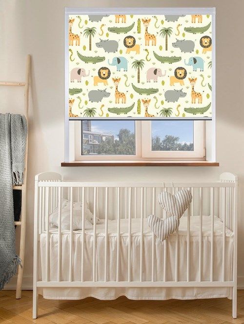 a baby's room with a white crib and window covered in jungle animals