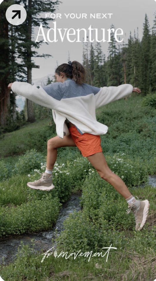 a woman is jumping in the air with her arms spread out and she's wearing an oversize sweater