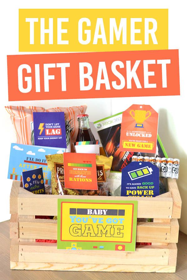 a wooden crate filled with games and snacks on top of a table next to a sign that says game gift basket