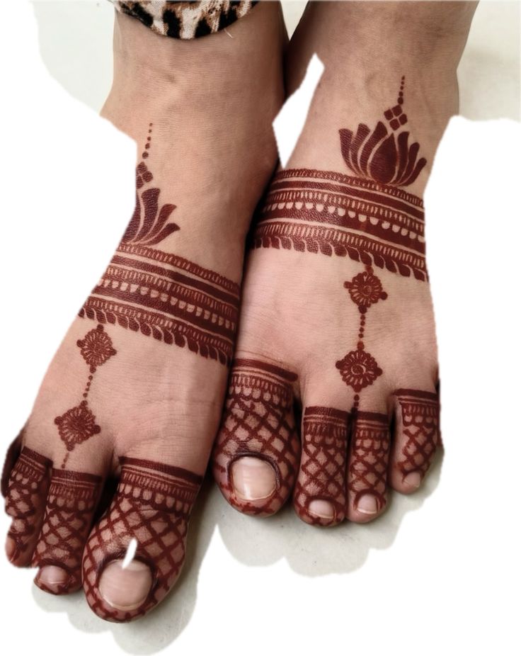 two feet with henna tattoos on them, one is white and the other is brown