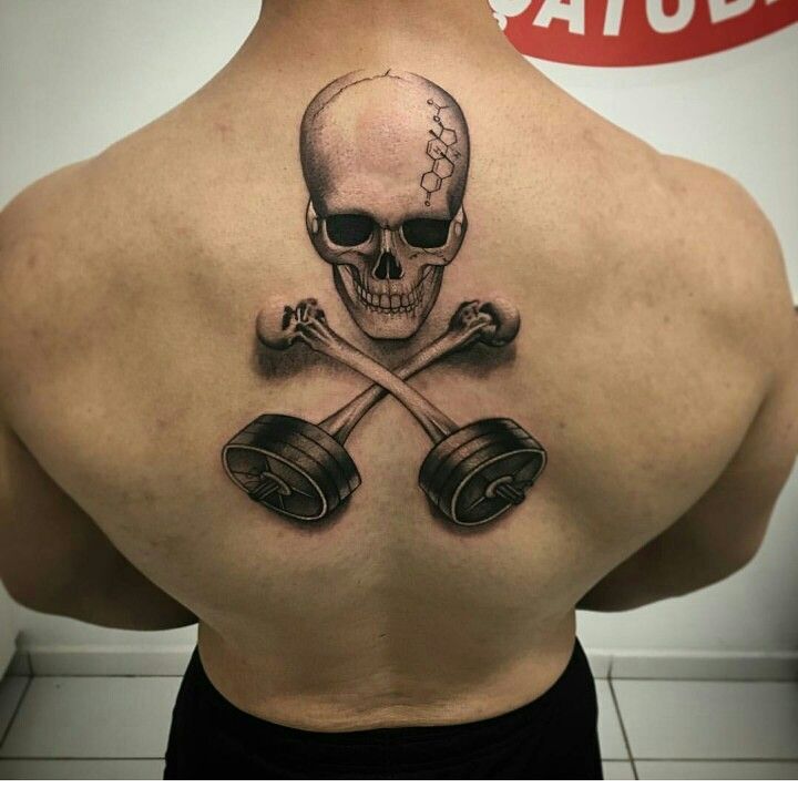 a man with a skull and two dumbs tattoo on his back