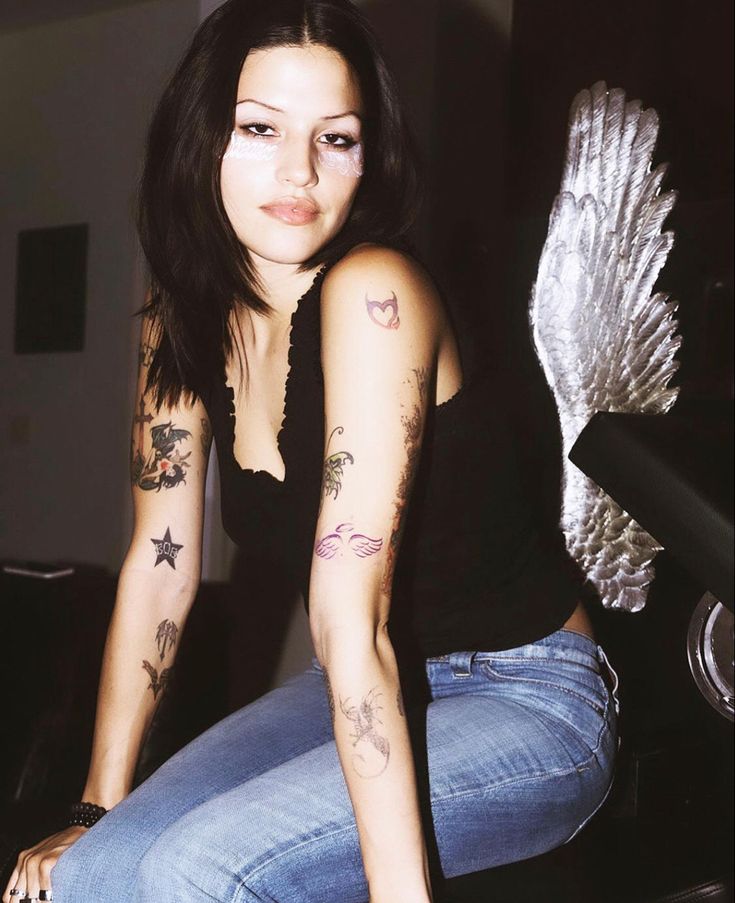 a woman with tattoos on her arm and leg