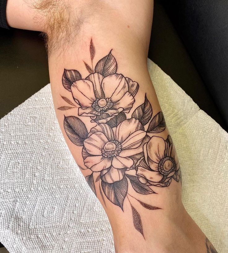 a black and white flower tattoo on the leg