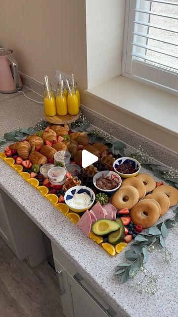 a kitchen counter topped with donuts and fruit on top of it next to drinks