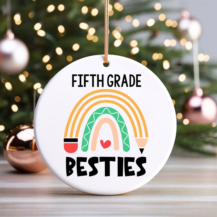 a ceramic ornament with the words fifth grade besties hanging from a christmas tree