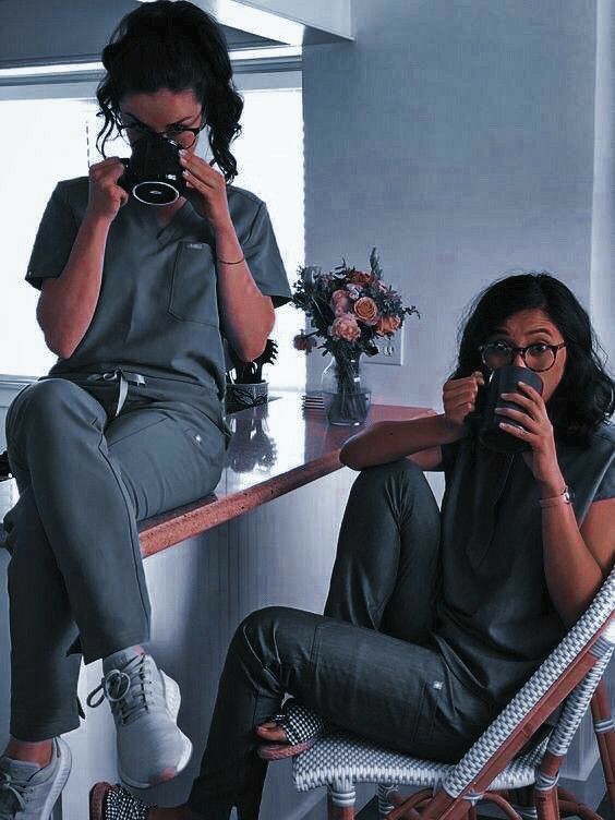 two women sitting at a table taking pictures