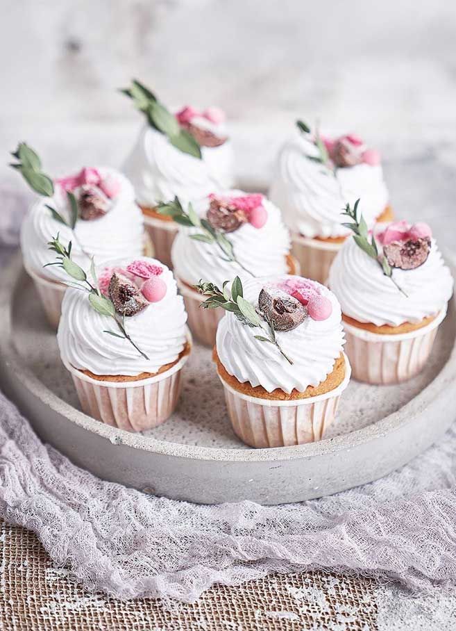 small cupcakes with white frosting and pink flowers