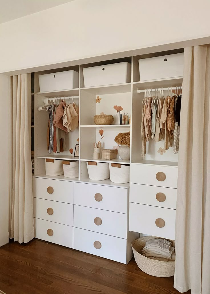 an organized closet with white drawers and beige curtains