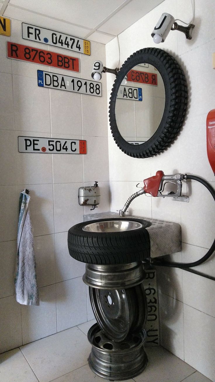 a bathroom with a sink, mirror and tires on the wall above it's faucet