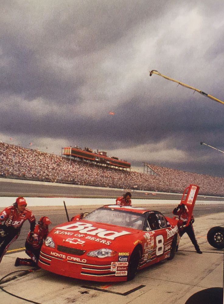 two men working on a race car in the pit