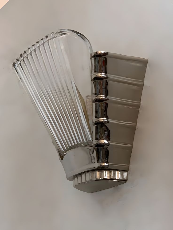 a wall mounted light fixture on the side of a white wall