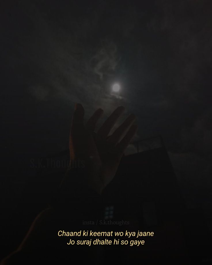 someone is holding their hand up to the sky at night with a full moon in the background