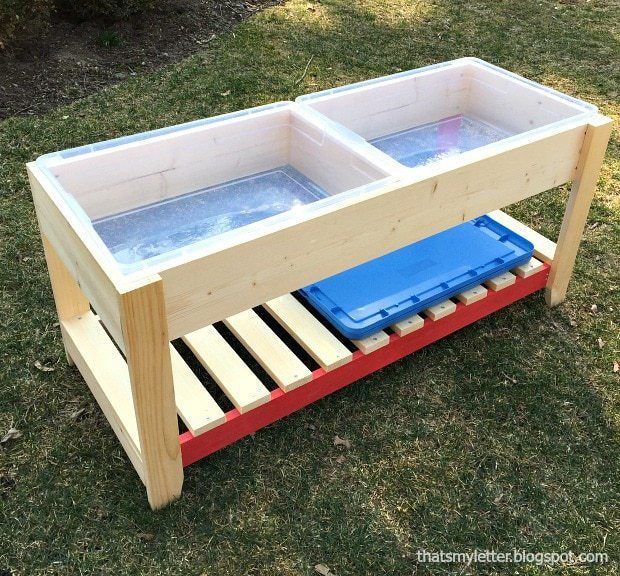 two plastic containers sitting on top of a wooden stand with water in them and one empty