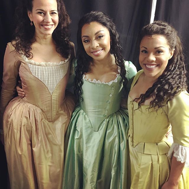 three women in dresses standing next to each other