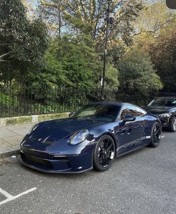 two blue sports cars parked on the street