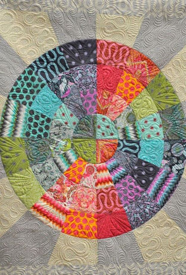 a circular quilt with many different colors and patterns