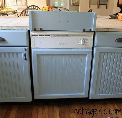 a kitchen with gray cabinets and white appliances