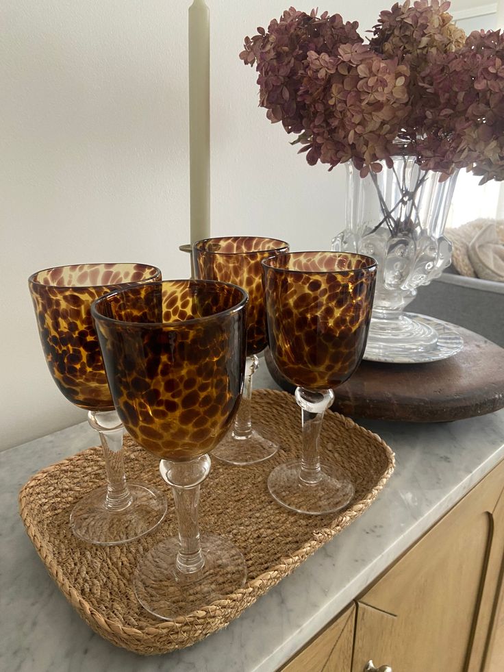 four wine glasses are sitting on a tray