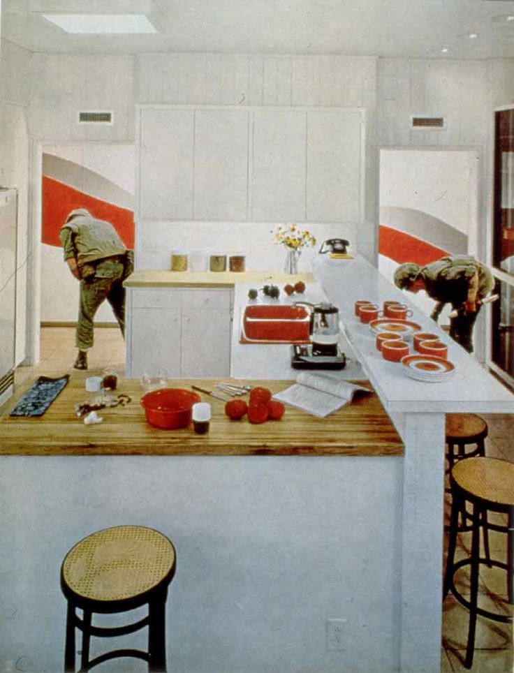 two men in the kitchen preparing food for people to eat at their stove top ovens