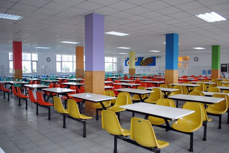 an empty classroom with yellow chairs and tables