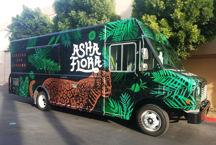 the food truck is decorated with green leaves and an image of a tiger on it's side