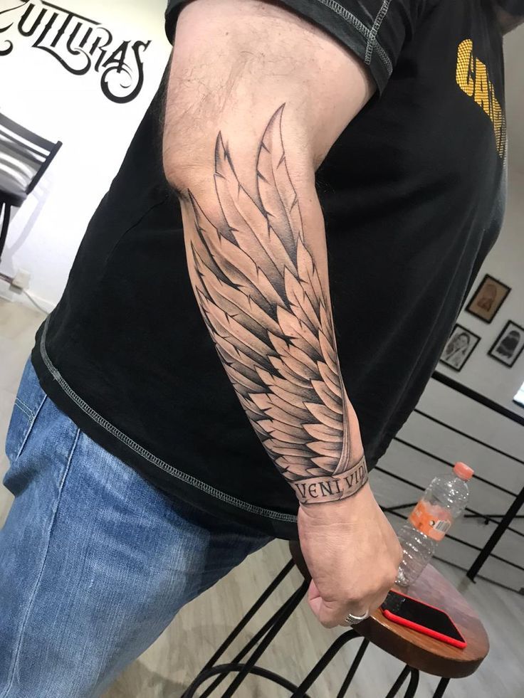 a man with a wing tattoo on his arm