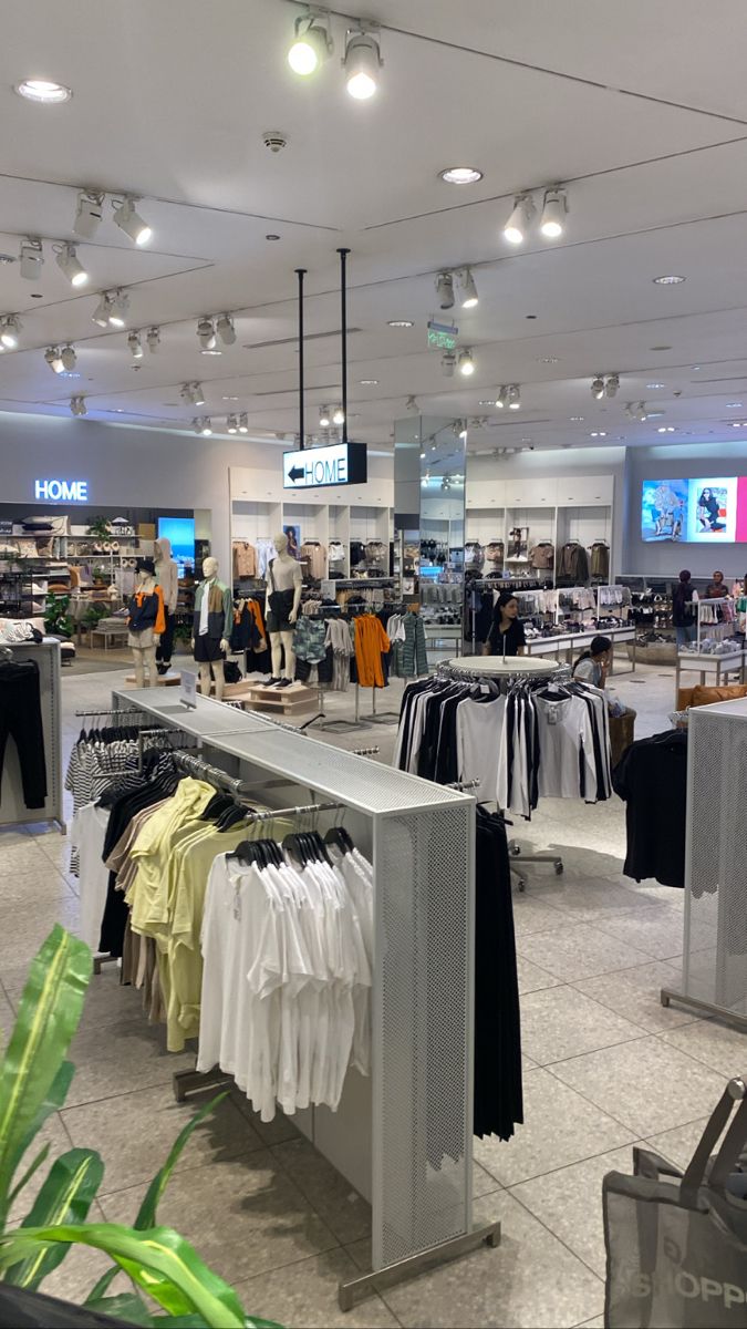 an open store with clothes on display and people shopping